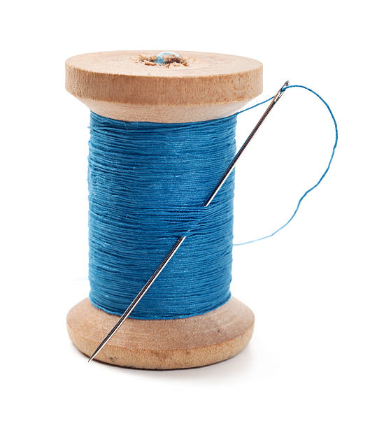 spool-of-blue-thread-with-a-needle-in-it-picture-id153653660
